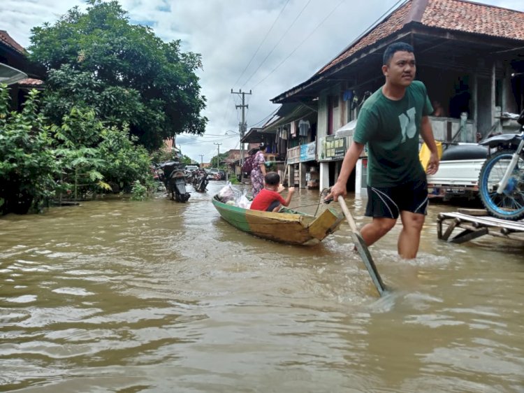 Tampak seorang anak menumpangi perahu saat evakuasi bencana banjir di Desa Betung, Kecamatan Benakat Muara Enim. (ist/rmolsumsel.id)