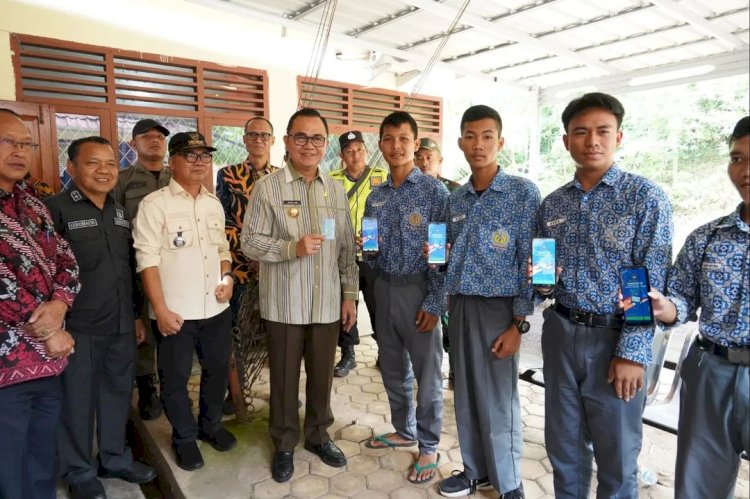Pj Bupati Banyuasin, Hani Syopiar Rustam membagikan KTP kepada para pelajar yang menjadi pemilih pemula pada Pemilu 2024. (ist/rmolsumsel.id) 