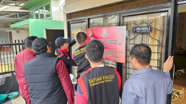 Petugas Kejari OKI melakukan pemasangan plang penyitaan di rumah milik mantan Kades Desa Bukit Batu berinisial AS. (ist/rmolsumsel.id)