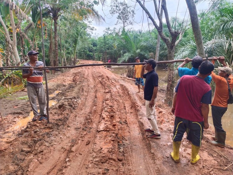 Warga Desa Pagar Bulan, Kecamatan Rantau Bayur, Banyuasin memasang portal kayu lantaran protes akses jalan mereka tak kunjung diperbaiki. (Arda Ismail/RMOLSumsel.id)