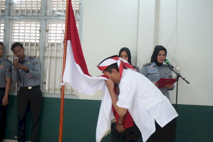 Salah seorang napi teroris mencium bendera Merah Putih usai mengucapkan ikrar setia kepada NKRI. (ist/rmolsumsel.id)