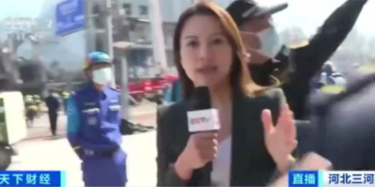 Tangkapan layar yang memperlihatkan seorang petugas menghalangi reporter CCTV melaporkan ledakan di Sanshe, hari Rabu (13/3)./VOA