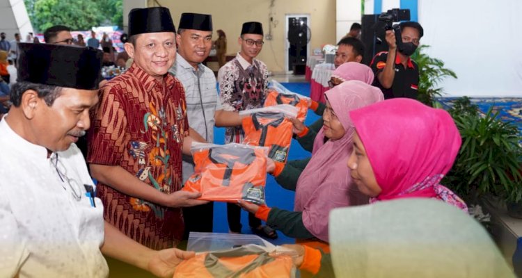 Bupati OKU Timur Ir Lanosin membagikan baju orange/ist