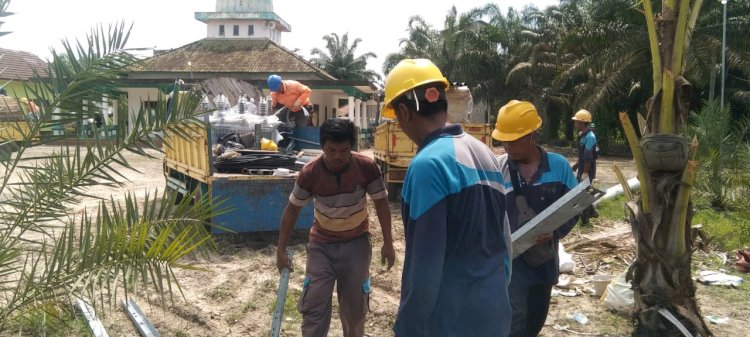 Warga Muba membantu petugas PLN membersihkan lokasi pembangunan jaringan. (ist/rmolsumsel.id)