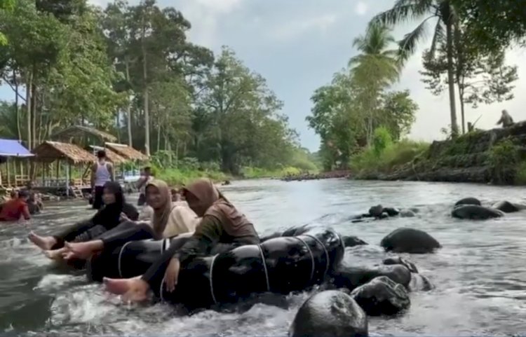 Pengunjung tengah menikmati objek wisata air sungai Kasie dengan beranyut pakai ban. (Handout)