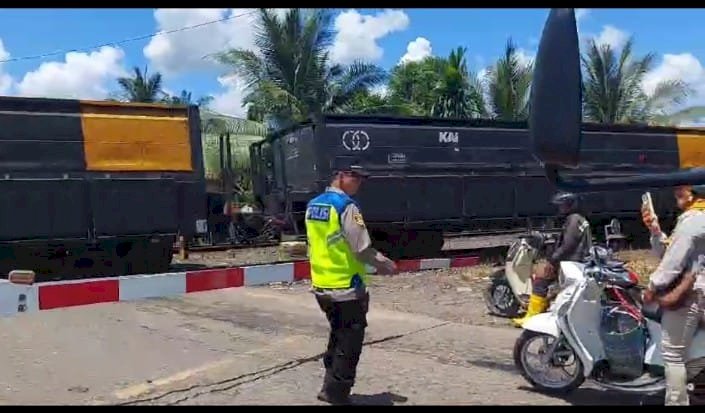 Personel Polres Muara Enim, menertibkan kendaraan di perlintasan sebidang rel Kereta Api (KA). (Dokumentasi Polisi)