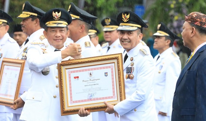 Pj Wali Kota Palembang, Ratu Dewa saat menerima penghargaan dari Mendagri, Tito Karnavian di Balai Kota Surabaya. (Istimewa)