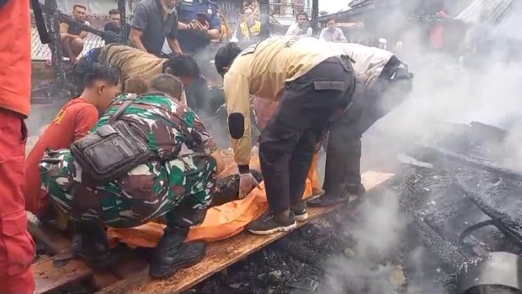 Petugas PMI Kota Palembang bersama warga sekitar saat mengevakuasi korban Rojali yang tewas terpanggang. (Denny Pratama/RMOLSumsel.id)