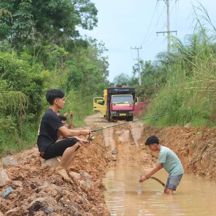 Jalan poros di Kelurahan Karya Makmur, Kecamatan Nibung, Muratara yang viral lantaran dijadikan tempat pemancingan ikan. (ist/rmolsumsel.id) 