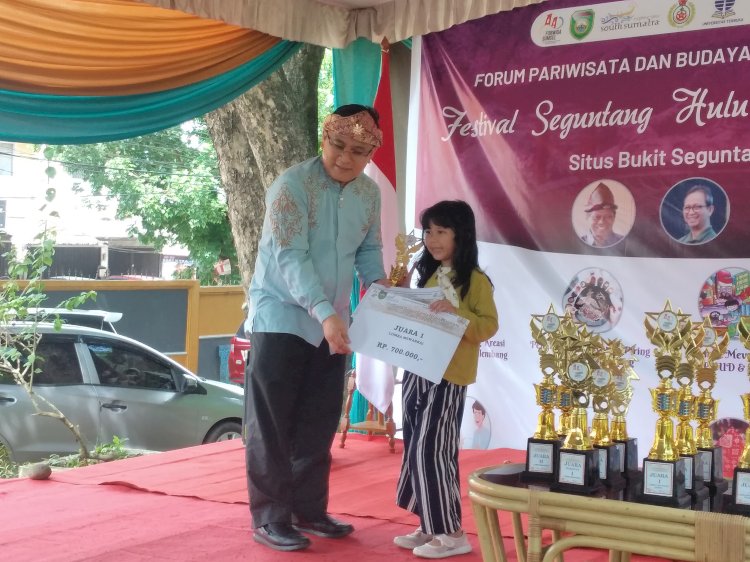 Sultan Palembang Darussalam RM Fauwaz Diradja saat menyerahkan hadiah kepada peserta lomba Festival Hulu Palembang. (dudi oskandar/rmolsumsel.id) 