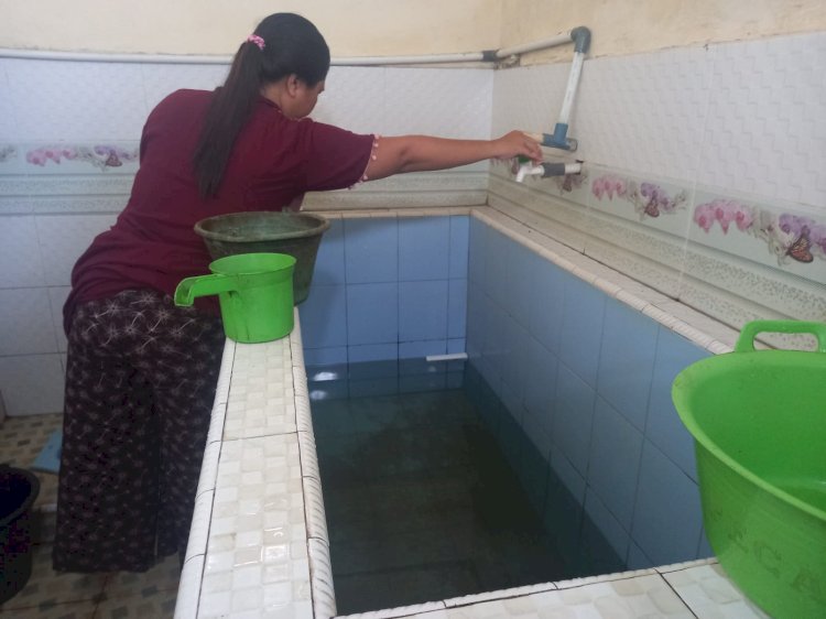Warga Air Lintang sedang menunjukan air PAM yang tidak mengalir dari kran di rumahnya (Noviansyah/RMOLSumsel.id)