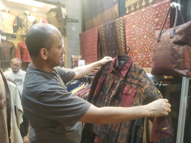  perancang busana asal Palembang sekaligus pemilik Brand Ilham Bahari yakni Muhammad Bilal saat menunjukan pakaian kemeja dari songket. (Denny Pratama/RMOLSumsel.id)
