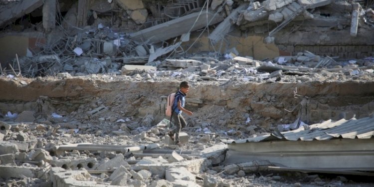 Seorang anak laki-laki Palestina berjalan di atas puing-puing, menyusul serangan Israel terhadap sebuah sekolah yang menampung para pengungsi, di tengah konflik Israel-Hamas, di Khan Younis, di selatan Jalur Gaza, pada Kamis, 27 Juni 2024/Net