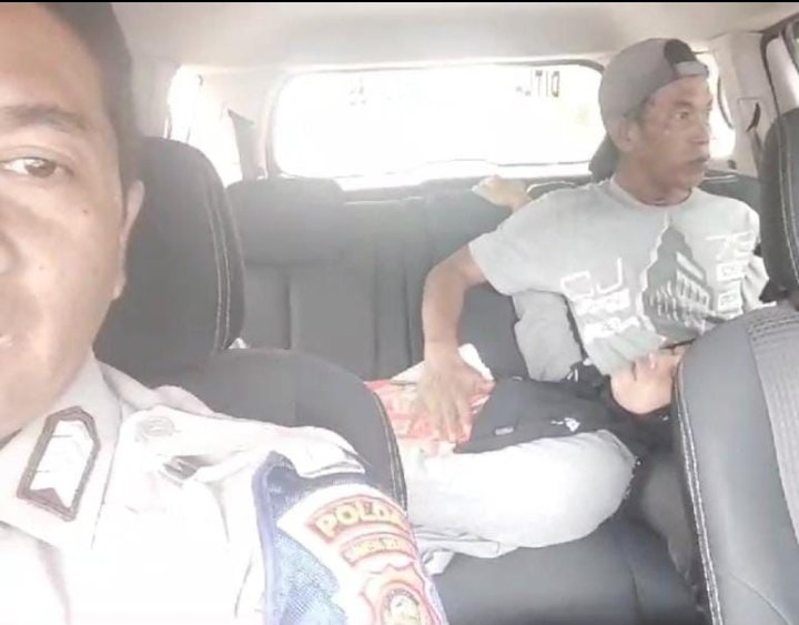 Bripka Gusti Dwi Riski saat memberikan pertolongan kepada seorang ibu yang hendak melahirkan. (Dokumentasi Polisi)