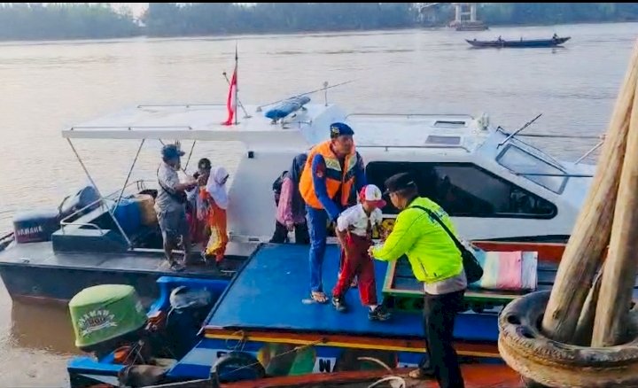 Polisi tengah menyebrangkan pelajar di Sungai Lalan. (Polda Sumsel/rmolsumsel.id)