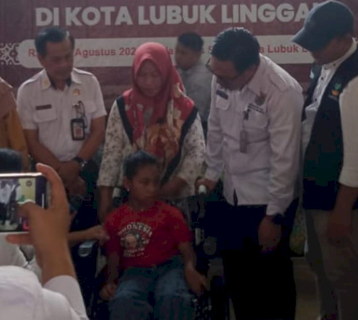 Aisyah saat mendapatkan kursi roda bantuan dari Dinas Sosial kota Lubuklinggau. Saat ini, kursi roda itupun telah hilang diambil pencuri. (Handout)