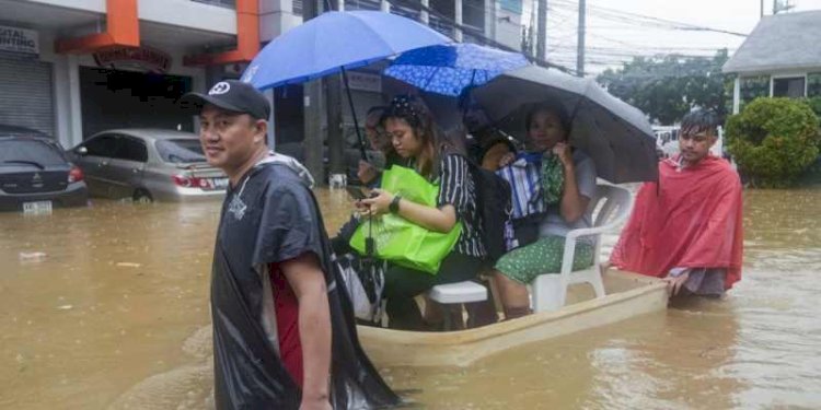 Warga menaiki pelampung dadakan melewati banjir yang disebabkan oleh hujan lebat akibat Badai Tropis Yagi hari Senin, 2 September 2024/AP