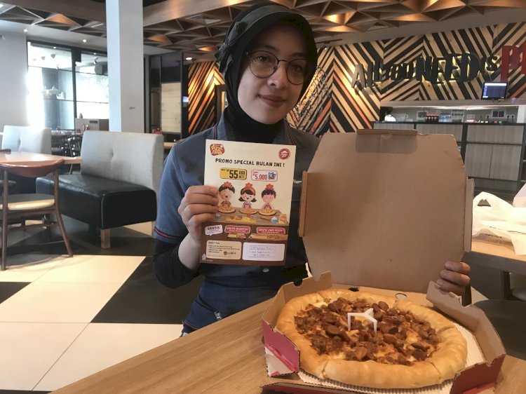 Pegawai pizza hut menunjukkan produk pizza (maya hasan/rmolsumsel.id)