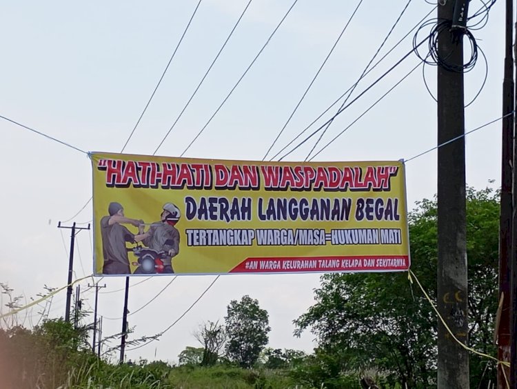 Spanduk rawan begal yang dipasang perangkat RT di Jalan Sukasari Palembang. (Fauzi/RMOLSumsel.id)
