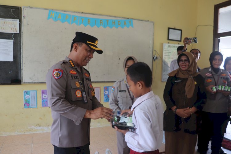 Irwasda Polda Sumsel, Kombes Pol Feri Handoko Soenarso saat membagikan makan siang dan susu gratis kepada siswa SDN 172 Palembang. (ist/rmolsumsel.id) 