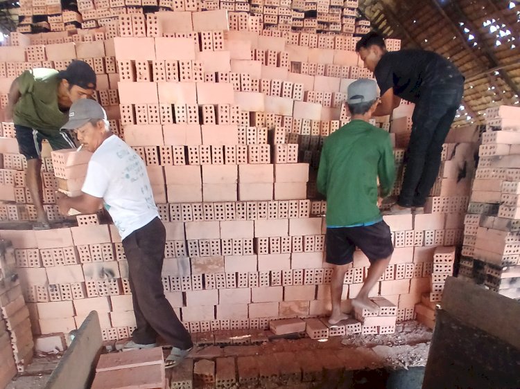 Pengrajin batu bata di Palembang tengah memindahkan batu bata ke mobil untuk dikirim. (sigit prasetya/rmolsumsel.id)