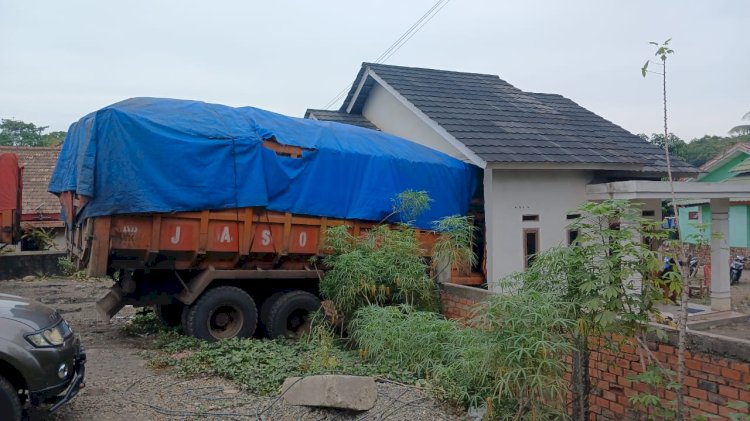 Truk Mitsubishi Fuso warna orange dengan nomor polisi BE 8936 AUA sarat muatan batu bara menabrak rumah warga di Dusun 5 Desa Karang Raja. (Dokumentasi Warga)