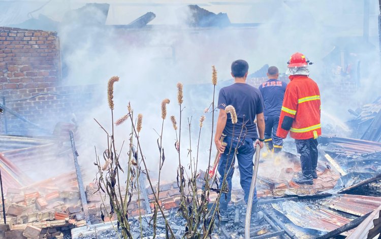 Petugas pemadam kebarakan mencoba memadamkan api yang menghanguskan dua rumah warga/ist