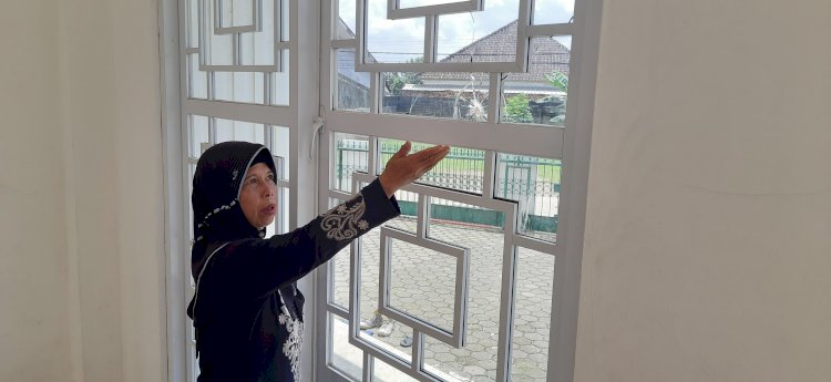 Idayati yang merupakan guru mengaji Masjid Ash Shomad memperlihatkan kaca pecah usai terdengar suara ledakan, Rabu (8/1/2025). (Fauzi/RMOLSumsel.id)
