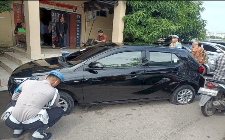 Subbid Provos Bidpropam Polda Sumsel kempiskan ban mobil yang parkir sembarangan di Mapolda/ist