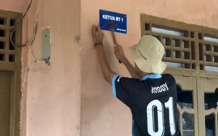 Mahasiswa KKN UIN Raden Fatah Palembang Kelompok 102 memasang plang nama di rumah perangkat Desa Tanjung Merbu/ist