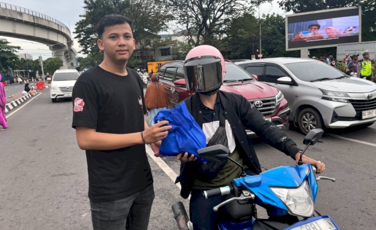 Salah satu peserta saat memberikan takjil pada penguna jalan/ist