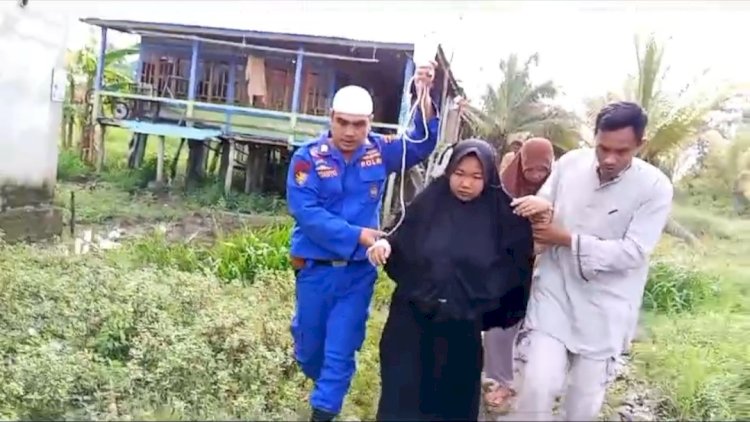 Bripka Ardianto saat membantu evakuasi ibu hamil yang mengalami keguguran untuk dibawa ke Rumah Sakit di Palembang. (ist/rmolsumsel.id)
