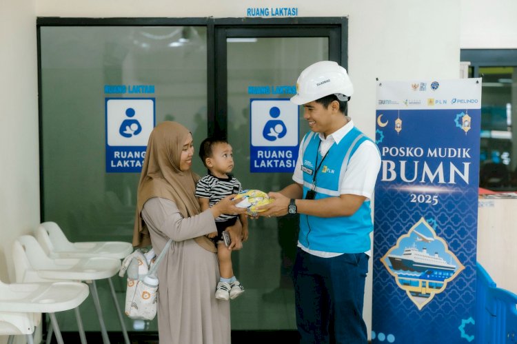 Petugas PLN Sujadmiko (kanan) sedang memberikan bingkisan bagi salah satu pemudik/ist