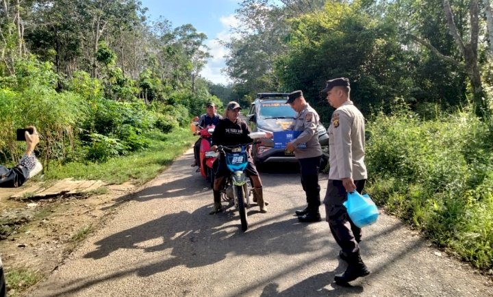 Polsek Rambang bagikan nasi kotak bagi masyarakat dan pengguna jalan yang melintas di Desa Sugih Waras Barat.