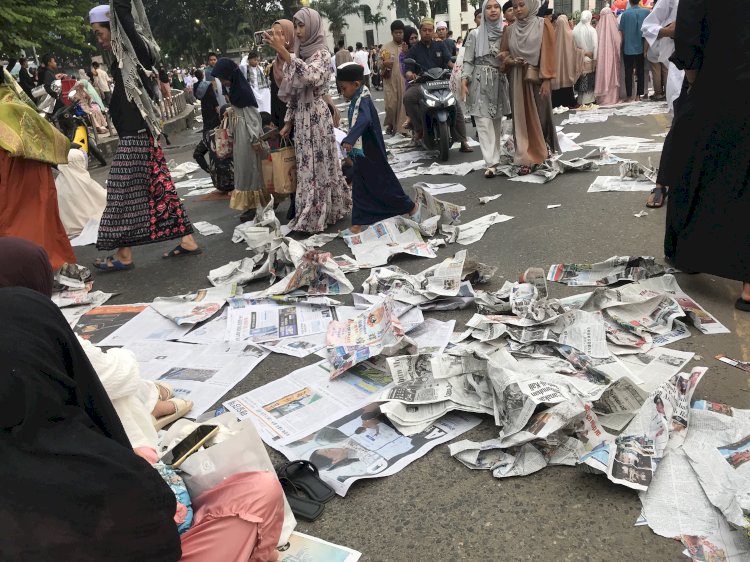 Tumpukan sampah koran bekas usai pelaksanaan shalat Idul Adha di kawasan masjid Agung Palembang, Jumat (6/6/2025). (Maya Hasan/ RMOLSumsel.id)